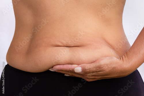 Фотография Copped female body with lower belly pooch on palm