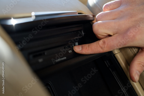 Canvas Print Passenger inserting SD memory card into multimedia slot in the center console of a luxury car