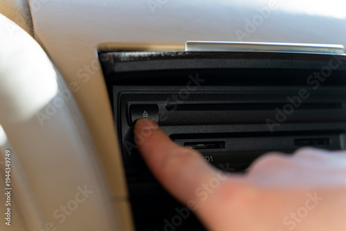 Canvas Print Passenger pressing eject button of car multimedia CD player in the center console of a luxury vehicle