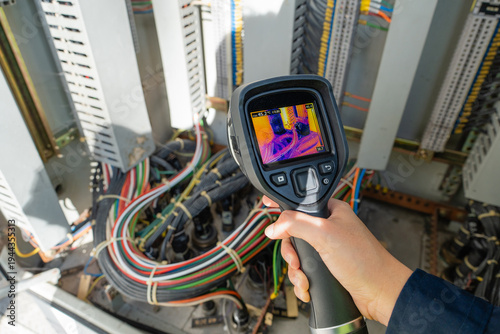Konstfotografi Thermal camera checks predictive maintenance inside an electrical control cabinet, detecting heat anomalies in cable connections to support safety, reliability, and diagnosis
