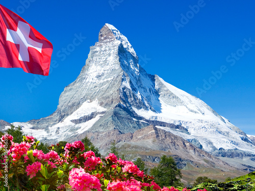 Matterhorn mountain peak with Swiss flag and alpine roses