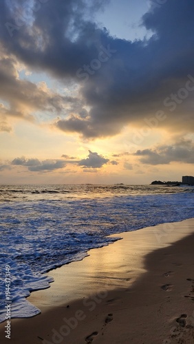 Golden Sunset Over Ocean Waves with Dramatic Clouds and Sandy Beach