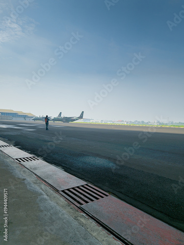 Obraz na płótnie Military Personnel Watching Aircraft on Airbase Runway with Wide Sky and Concret
