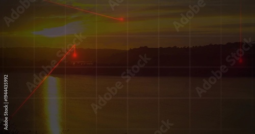 Sinking sun sending vertical reflection across calm lake at dusk, with grid overlay and red lasers
