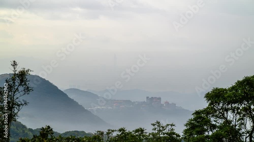 A misty morning view of Taipei City from Datun Mountain in Beitou, featuring the iconic Taipei 101 skyscraper emerging through clouds and fog.