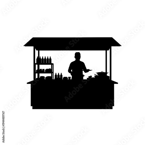 Silhouette of a street food vendor preparing food at a stall with bottles and pans
