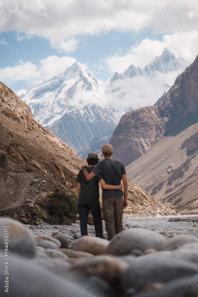 Fototapeta premium Friends hugging admiring snow capped mountains on baltoro trek. Baltoro