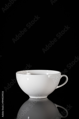 White ceramic tea cup on black background