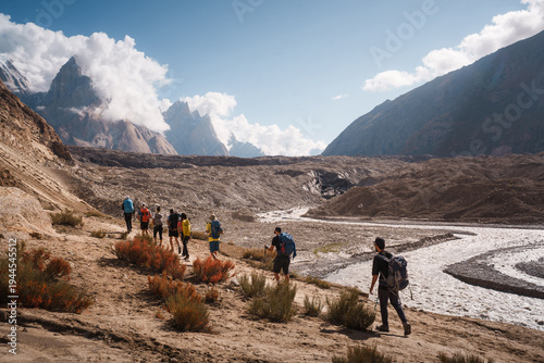 Trekkers walking baltoro glacier trail under trango towers. Paiju koburtse