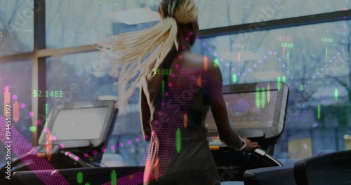 Running woman in dark workout wear using treadmill with console by big window, with stock charts