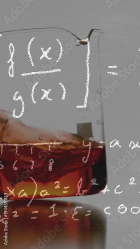 Vertical video: Amber liquid in beaker reacting to ice cube entering forming waves lab math overlay