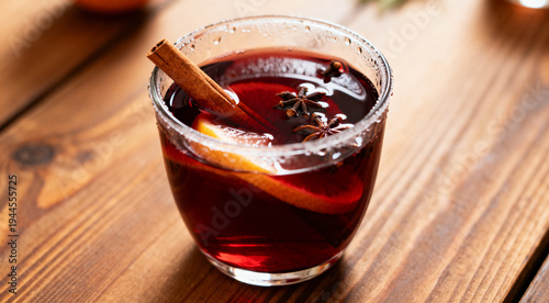 Hot spiced mulled wine served on wooden table, closeup view.