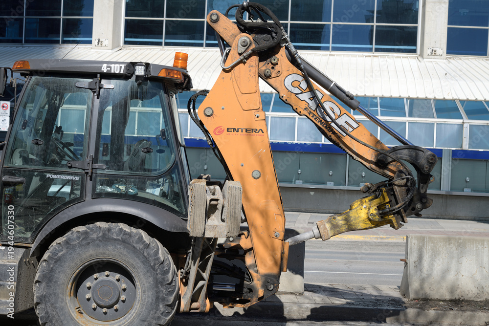 Fototapeta premium CASE Extendahoe, a telescoping backhoe dipper arm designed for increased reach and dig depth, often fitted with a CASE Hydraulic Breaker (Rock Hammer) using a Moil Point bit for concrete and rock demo