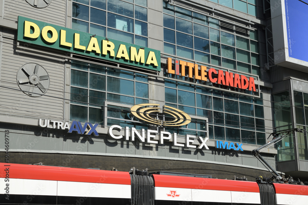 Obraz premium signs on the exterior of The Tenor, a multi-use commercial complex featuring Cineplex, Dollarama, and Little Canada—a massive indoor miniature attraction—located at 10 Dundas St E, Sankofa Square, TO