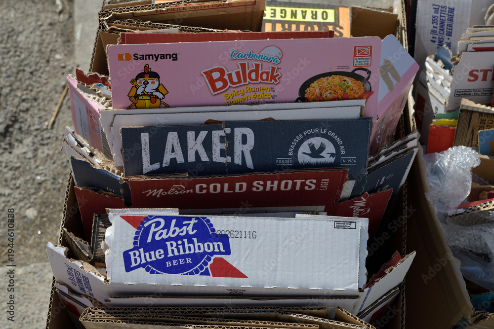Naklejka premium bundles of cardboard boxes with labels showing including Pabst Blue Ribbon, Molson Cold Shots, Laker, and Buldak, Toronto