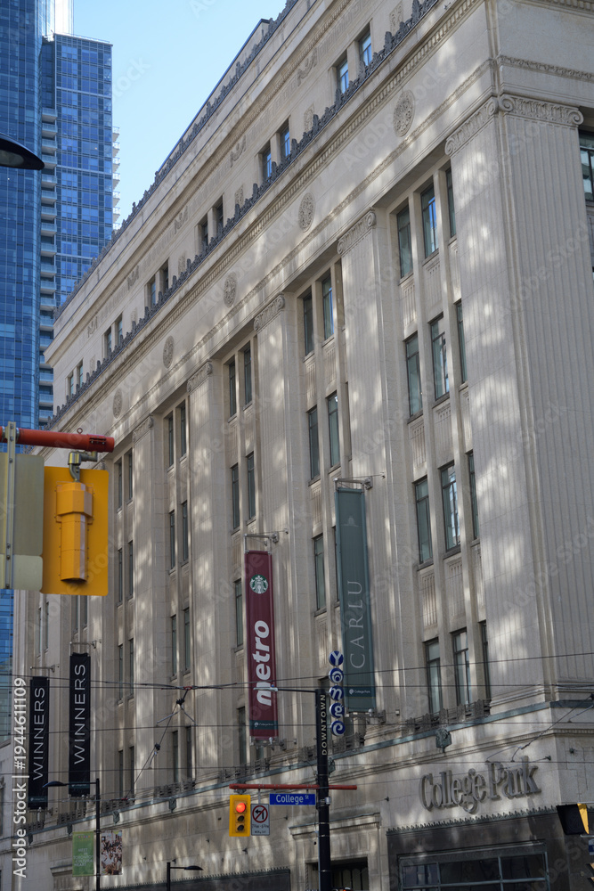 Fototapeta premium facade of College Park, a shopping mall (formerly Eaton's College Street), with wall mounted banners for Metro supermarket at 444 Yonge St, Toronto