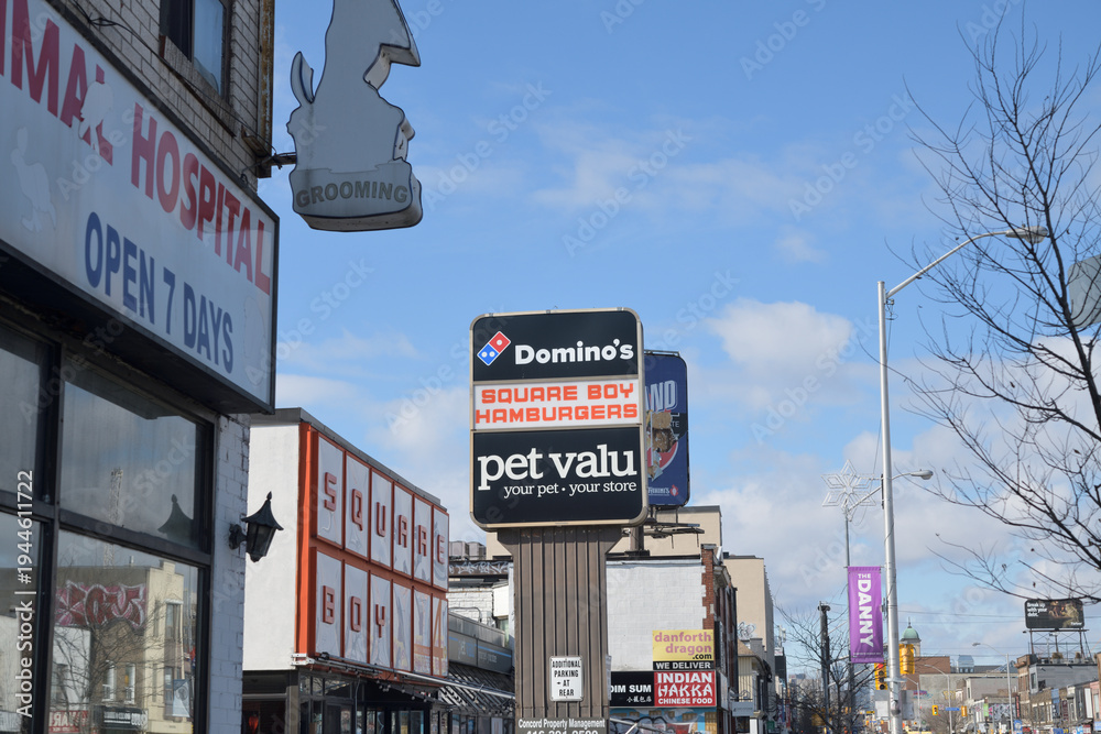 Fototapeta premium roadside pylon sign with Domino's Pizza, Square Boy restaurant, and Pet Valu, pet supply store, Danforth Av, Toronto