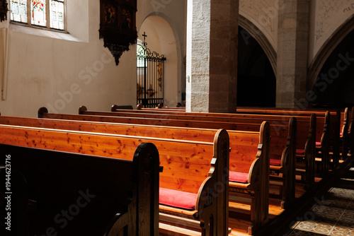 Foto Rows of traditional carved wooden pews create a perspective view inside a historic church in Austria, showcasing sacred architecture and quiet devotion