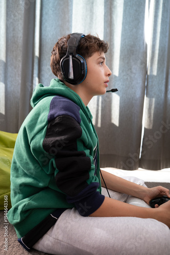 Teenager Sitting on Floor Playing Video Games at Home, close up