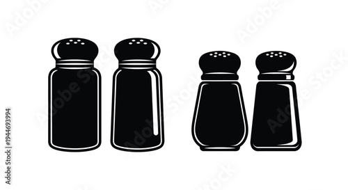 Four black salt and pepper shakers displayed in a dark silhouette