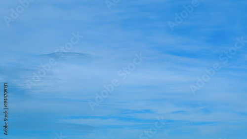 Canvas Print A tranquil blue sky adorned with soft, fluffy clouds that create an inviting atm