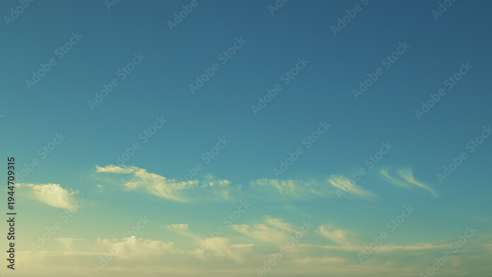 Fototapeta premium A Serene Blue Sky adorned with Whimsical Clouds for a breathtaking view of tranquility