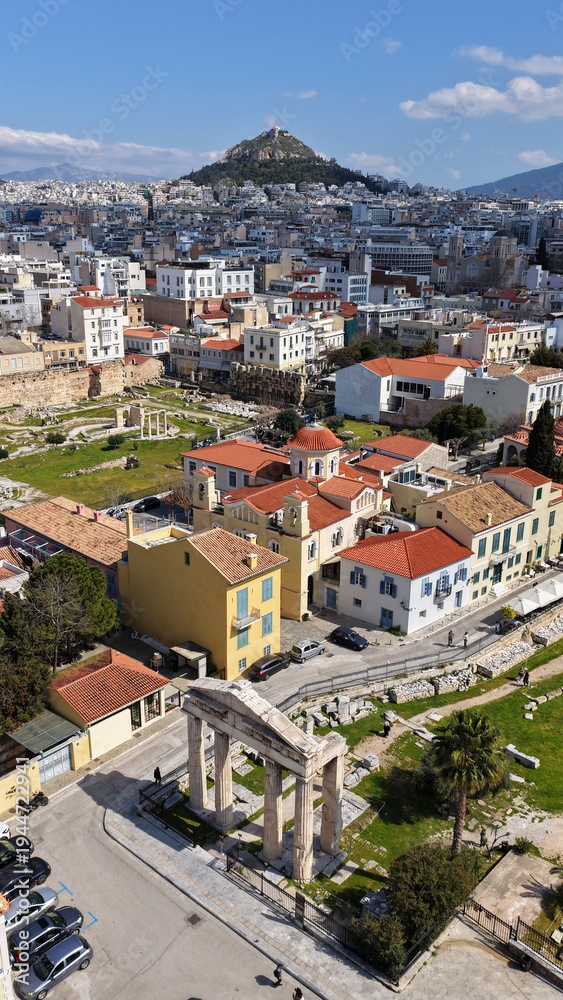 Fototapeta premium Aerial drone portrait photo of ancient Roman Market featuring tower of Winds and Gate of Athena in the heart of Athens historic centre built in Plaka district, below Acropolis hill, Attica, Greece