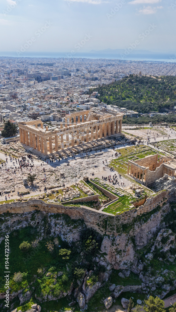 Fototapeta premium Aerial drone photo above Acropolis hill and the Parthenon featuring Propylaea and porch of the Caryatids, Athens historic centre, Attica, Greece