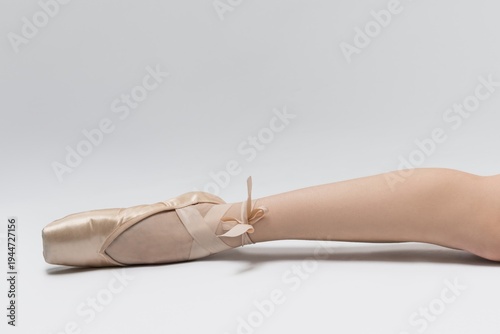 Ballet dancer showing a pointed toe on the floor with a soft background during a practice session in a studio