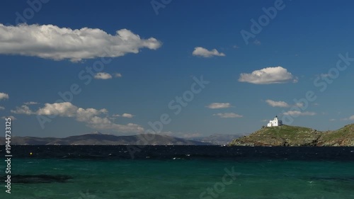 Wide view of Korissia Bay on Kea Island in the Cyclades, Greece, with the lighthouse visible on the headland and wind driven waves across the Aegean Sea, filmed in late winter to early spring with nat
