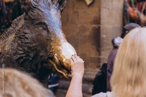 Foto Tourist touching Il Porcellino bronze boar statue snout for good luck in Florenc