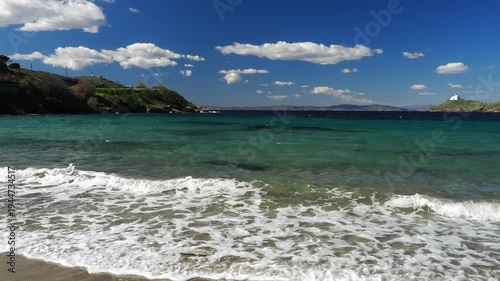 Wide view of Korissia Bay on Kea Island in the Cyclades, Greece, with the lighthouse visible on the headland and wind driven waves across the Aegean Sea, filmed in late winter to early spring with nat