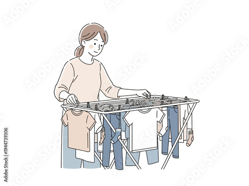 Woman hanging clothes on a drying rack indoors.