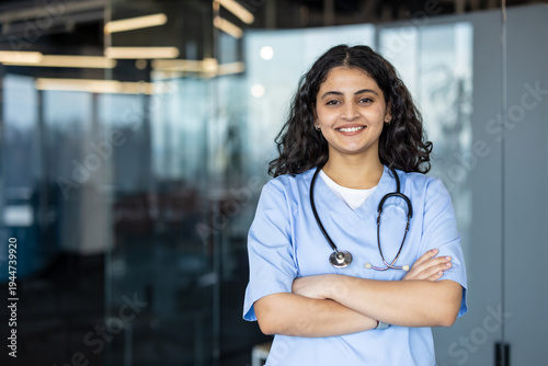 Canvastavla Young female medical professional in scrubs and stethoscope smiling, standing wi