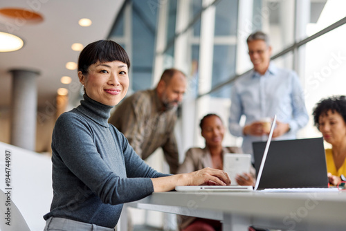 Portrait of a group of young business people having a meeting in the office. Teamwork and success concept, portrait of a smart young businesswoman using a laptop