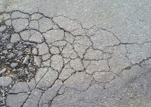Fotografie Damaged asphalt road surface with severe alligator cracking pattern