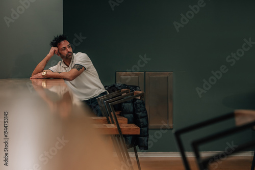 young man sitting alone indoors waiting