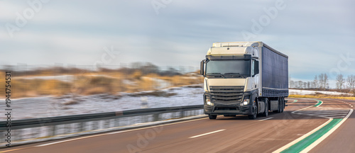 Large cargo truck transporting freight on snowy winter highway. Freight truck on road.