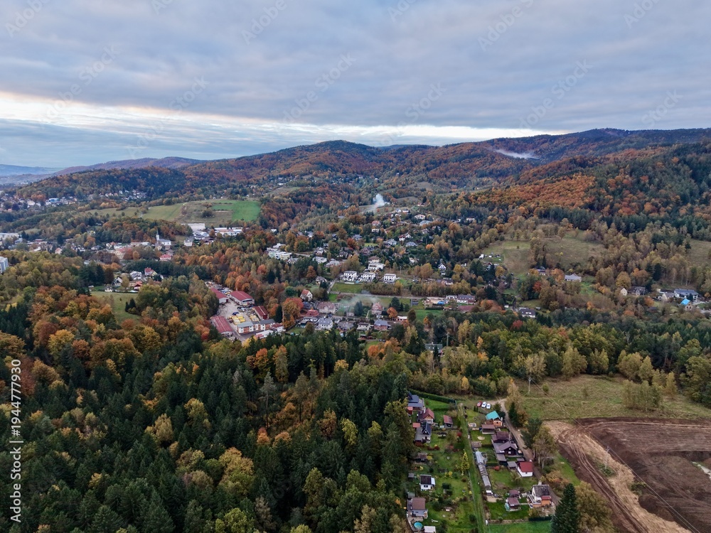 Obraz premium rolling moody hills meet city outskirts, dramatic elevated terrain with village and city views