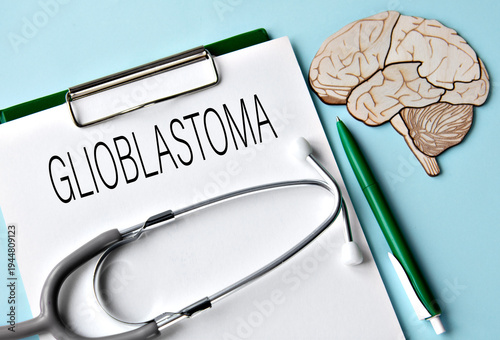 GLIOBLASTOMA - word on white sheet on blue background and skull mockup