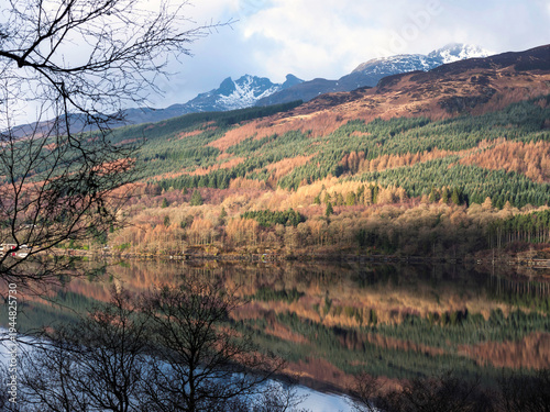 фотографія Ben Arthur, better known as The Cobbler, seen from the West Highland Way on the east bank of Loch Lomond with mirror-like reflections of the autumn colours in the calm water