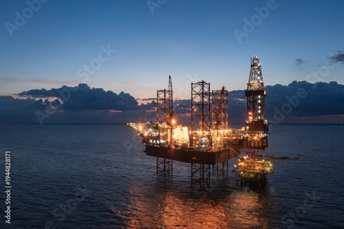 Fotografie Aerial view of offshore jack up rig and offshore platform during sunset for oil and gas exploration and production