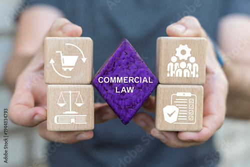 Concept of commercial law. Person holding blocks with icons sees the text COMMERCIAL LAW.