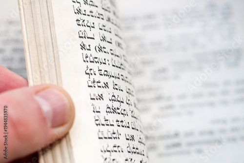 Hand Turning Page of Antique Hebrew Prayer Book