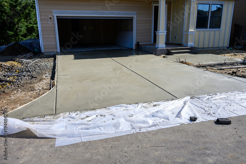 Obraz na płótnie New home construction, housing supply, freshly poured wet concrete driveway and