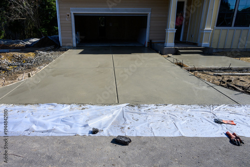 Valokuva New home construction, housing supply, freshly poured wet concrete driveway and
