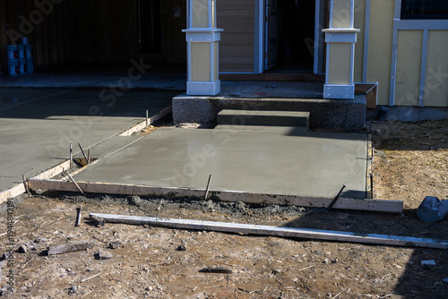 Φωτογραφία New home construction, housing supply, freshly poured wet concrete driveway and
