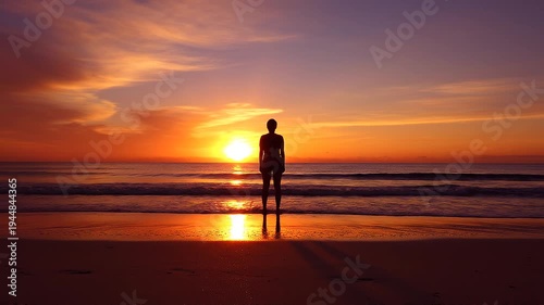 Man standing on beach at sunset.
