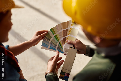 Obraz na plátne Close up of couple choosing color from color swatch at renovating home