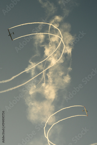 Aerobatic airplane drawing white smoke trails in the sky